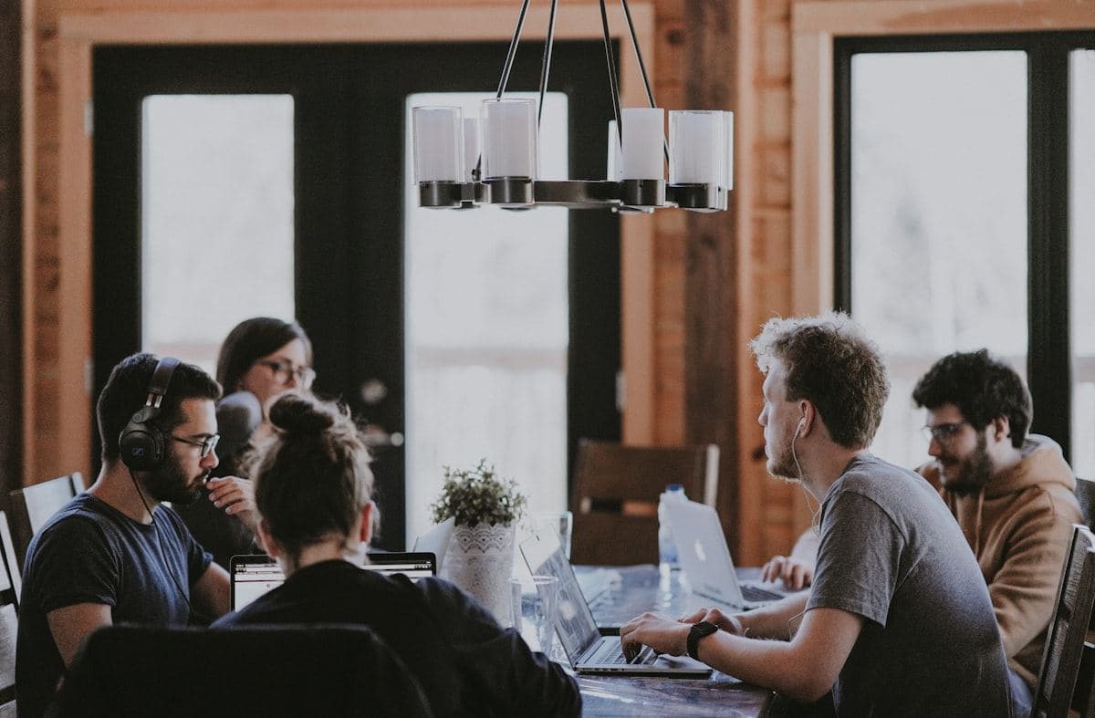 Profesionales trabajando alrededor de una mesa con portátiles